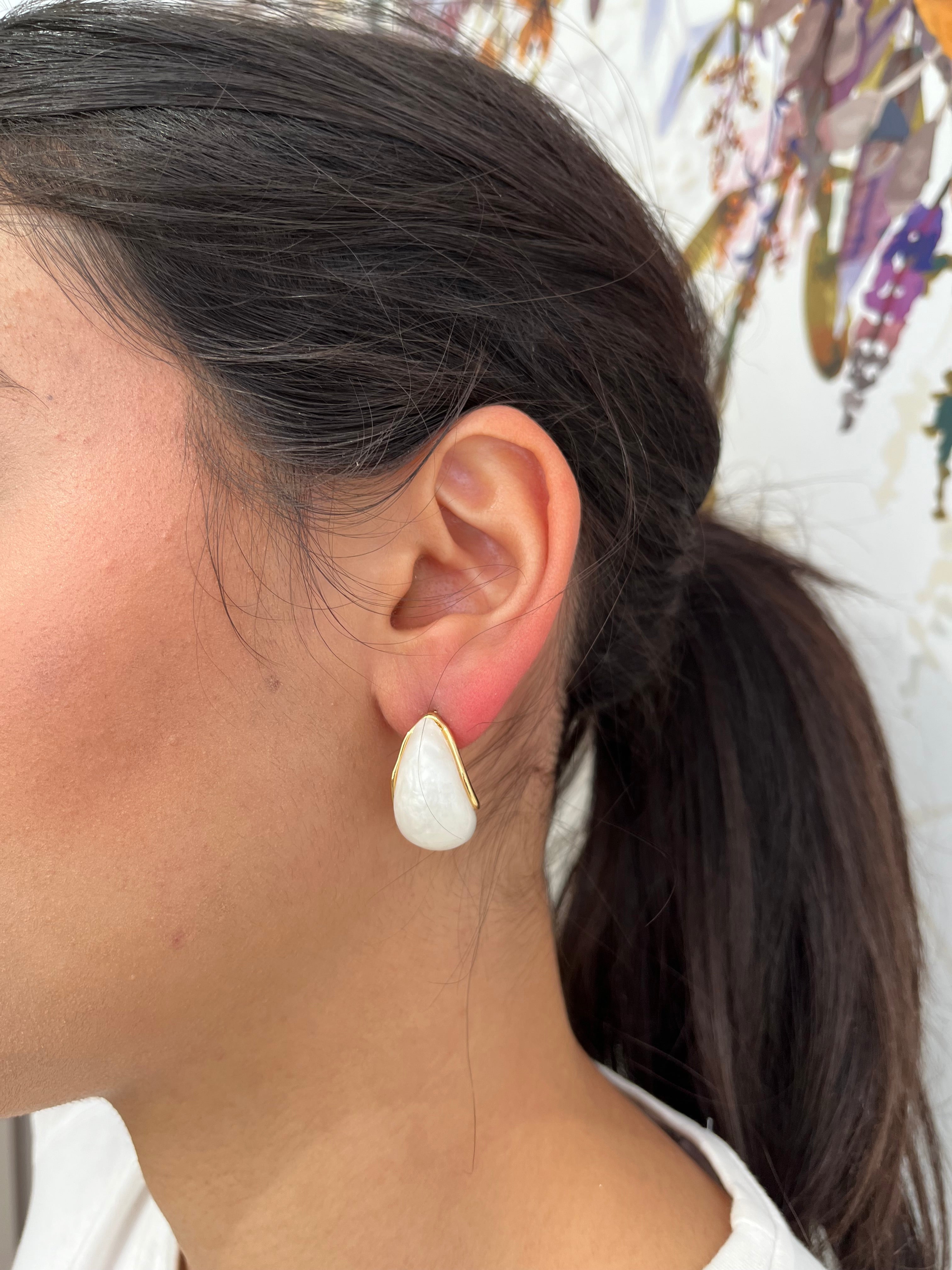 Boucles d'oreilles Horia blanches en forme de goutte portées de profil.