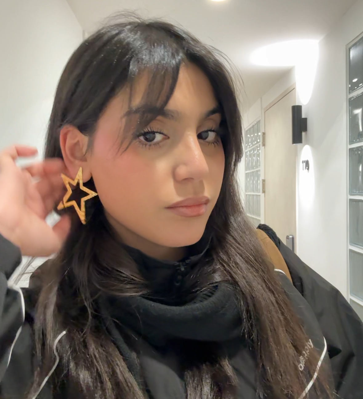 Gros plan des boucles d'oreilles STARS en forme d'étoile dorée portées - Bijou Ordiajade