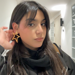 Gros plan des boucles d'oreilles STARS en forme d'étoile dorée portées - Bijou Ordiajade