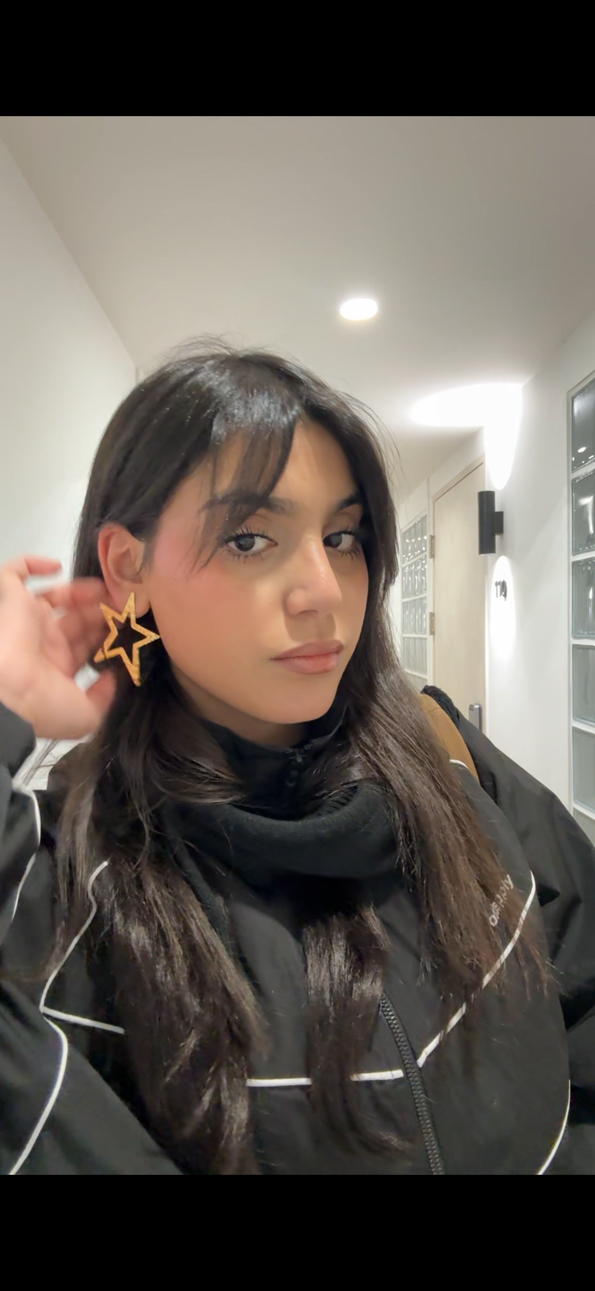 Gros plan des boucles d'oreilles STARS en forme d'étoile dorée portées - Bijou Ordiajade