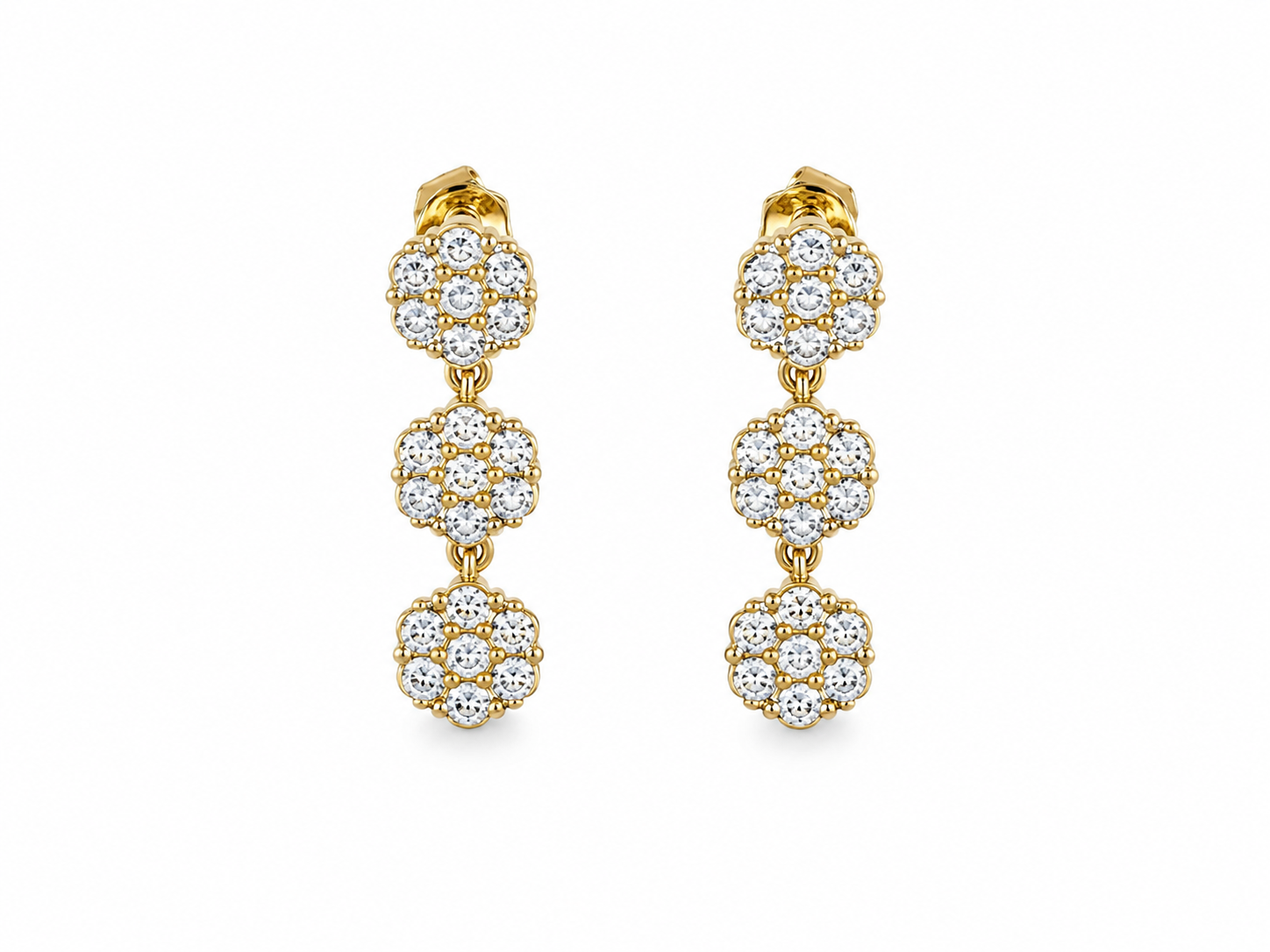 Paire de boucles d'oreilles pendantes dorées composées de trois motifs fleurs ciselés posée à plat - Ordiajade