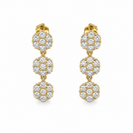 Paire de boucles d'oreilles pendantes dorées composées de trois motifs fleurs ciselés posée à plat - Ordiajade