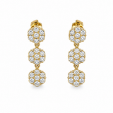 Paire de boucles d'oreilles pendantes dorées composées de trois motifs fleurs ciselés posée à plat - Ordiajade