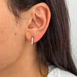 Gros plan sur les boucles d'oreilles Juliana portées, design moderne et épuré