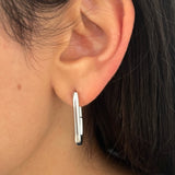 Boucles d'oreilles Karen argentées portées, créoles géométriques pour un look moderne