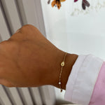 Bracelet Amenie en acier inoxydable doré avec motif goutte porté au poignet - Ordiajade