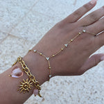 Bracelet de poignet Ordiajade en acier inoxydable doré avec breloques soleil et cœur rose nacré.