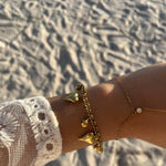 Bracelet Cœur Grelo doré porté en accumulation au poignet à la plage - Ordiajade