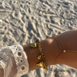 Bracelet Cœur Grelo doré porté en accumulation au poignet à la plage - Ordiajade