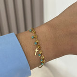 Bracelet Croix Ocean doré en acier inoxydable avec pampilles perles turquoises porté au poignet - Ordiajade