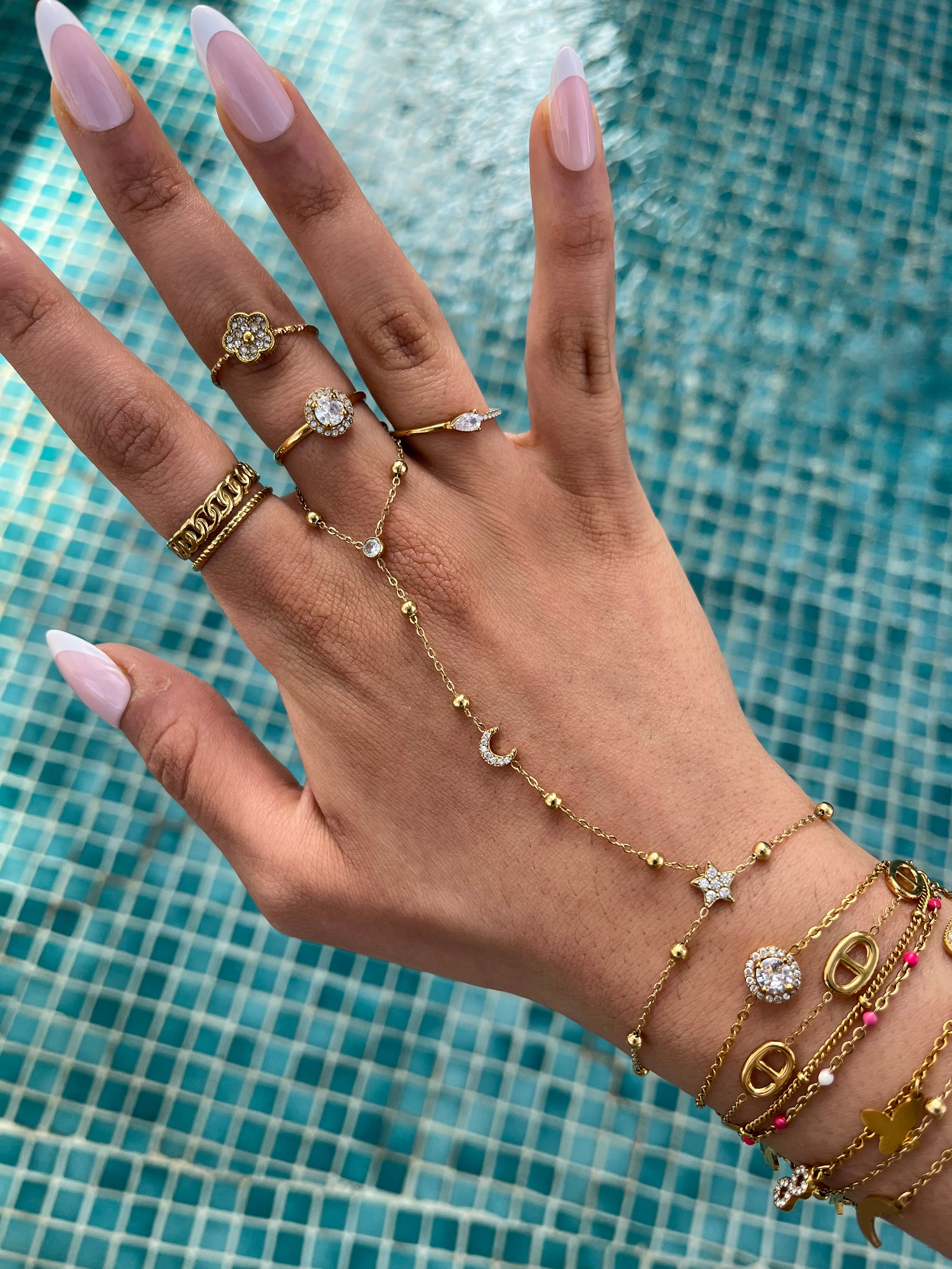 Gros plan d'un bracelet de main bohème chic avec pendentifs lune et étoile étincelants.