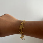 Bracelet Eden doré en acier inoxydable avec des motifs floraux délicats porté au poignet Ordiajade