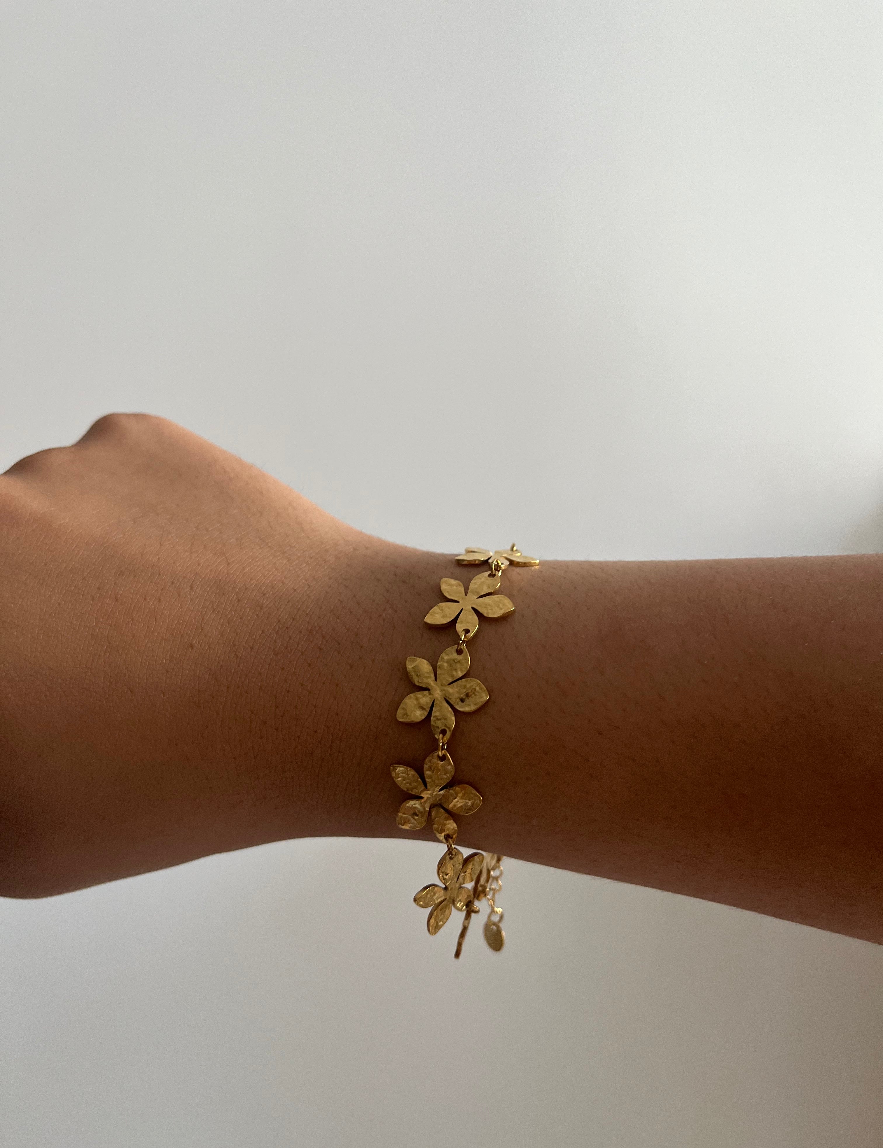 Bracelet Eden doré en acier inoxydable avec des motifs floraux délicats porté au poignet Ordiajade