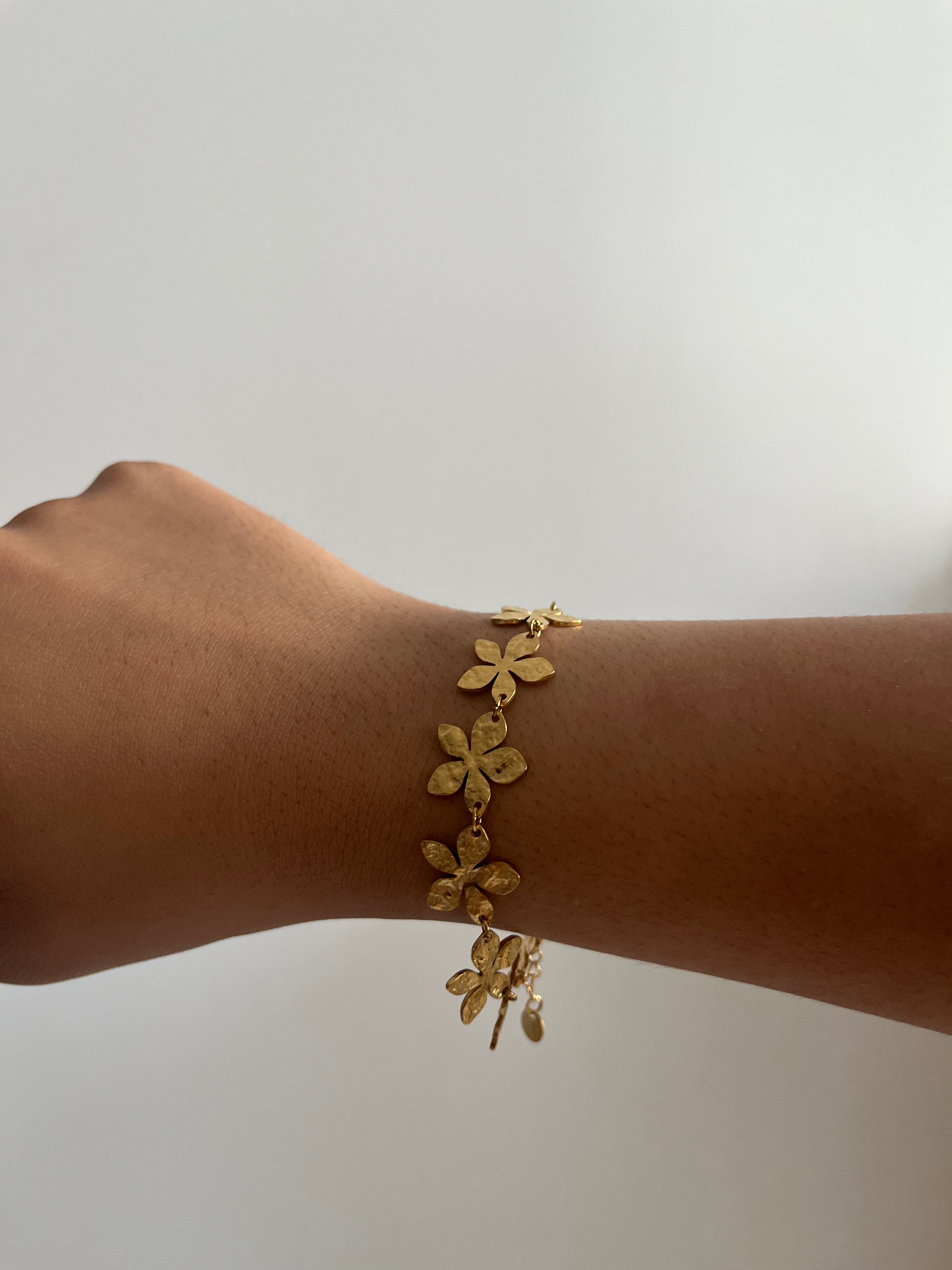 Bracelet Eden doré en acier inoxydable avec des motifs floraux délicats porté au poignet Ordiajade