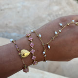 Accumulation de bracelets dorés fins au poignet avec le bracelet Éléonore en acier inoxydable et ses charms suspendus - Ordiajade