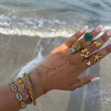 Gros plan du bracelet doré EYE porté au poignet en accumulation avec d'autres bijoux - Ordiajade