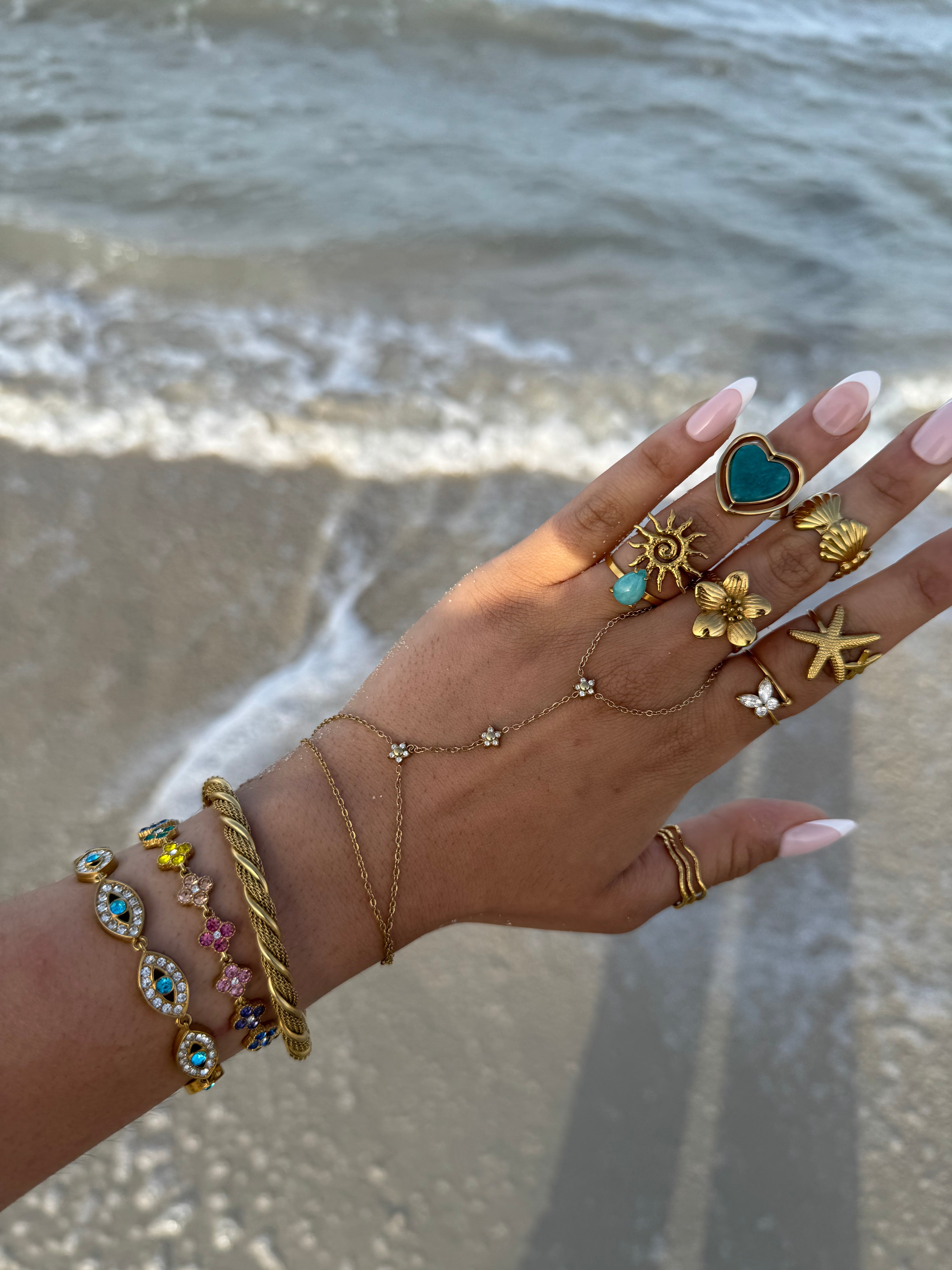 Gros plan du bracelet doré EYE porté au poignet en accumulation avec d'autres bijoux - Ordiajade