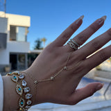 Gros plan du bracelet doré EYE porté au poignet en accumulation avec d'autres bijoux - Ordiajade