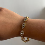Bracelet Eye White en acier inoxydable doré avec détails fins et lumineux porté au poignet Ordiajade