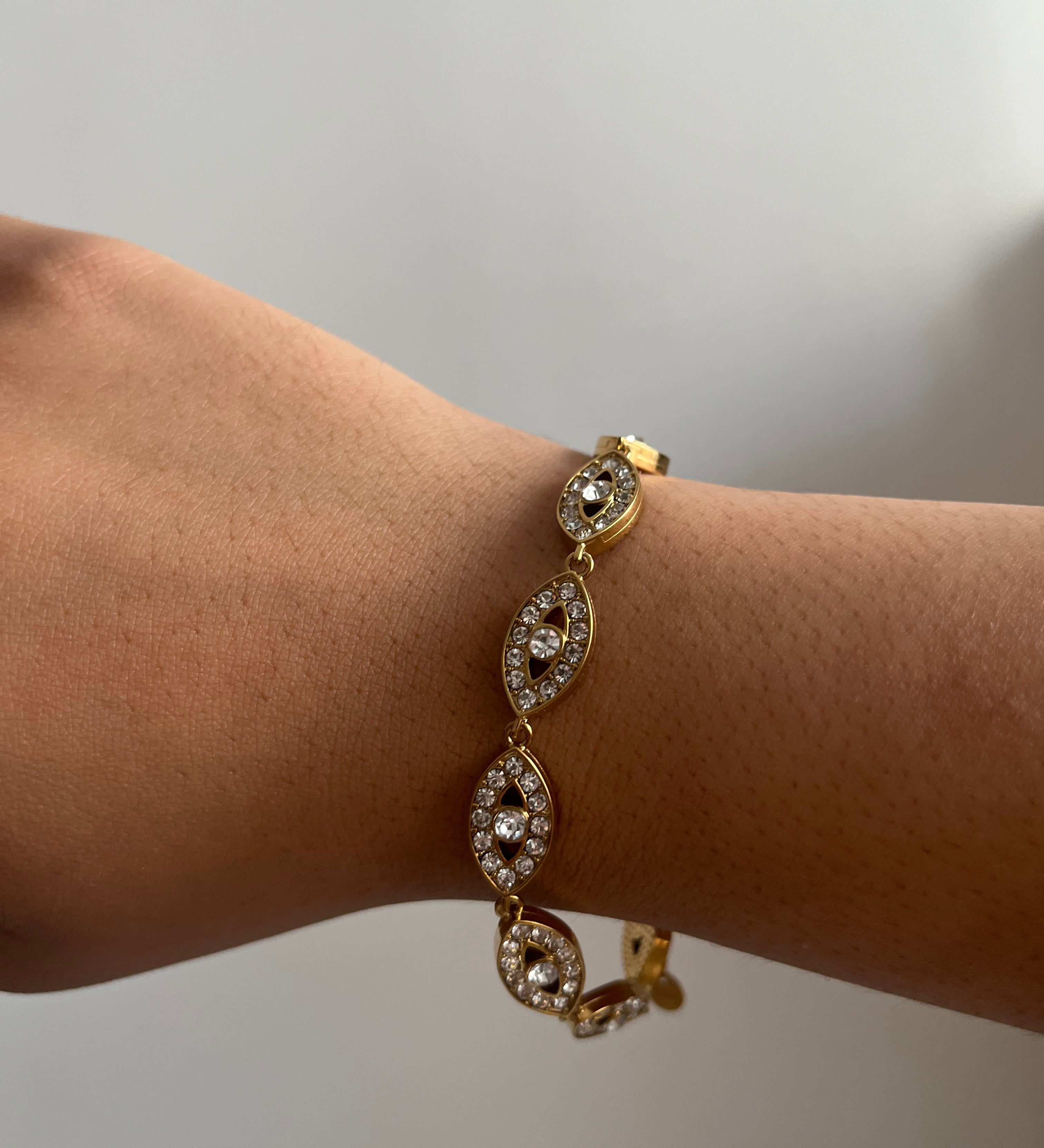 Bracelet Eye White en acier inoxydable doré avec détails fins et lumineux porté au poignet Ordiajade