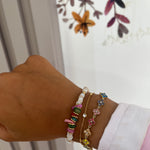 Bracelet Hailey doré en acier inoxydable à fleurs pavées porté en accumulation au poignet - Ordiajade