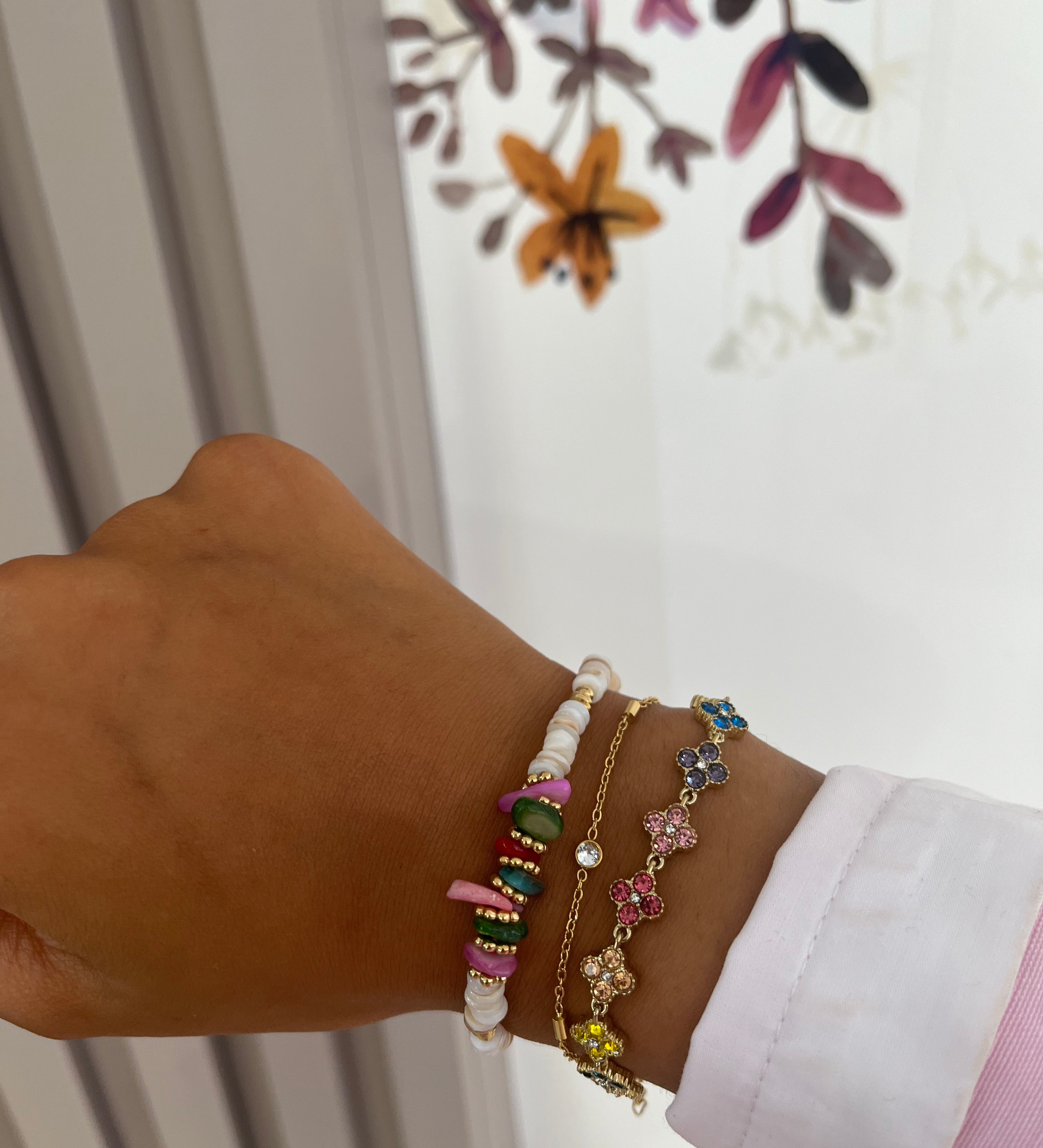 Bracelet Hailey doré en acier inoxydable à fleurs pavées porté en accumulation au poignet - Ordiajade