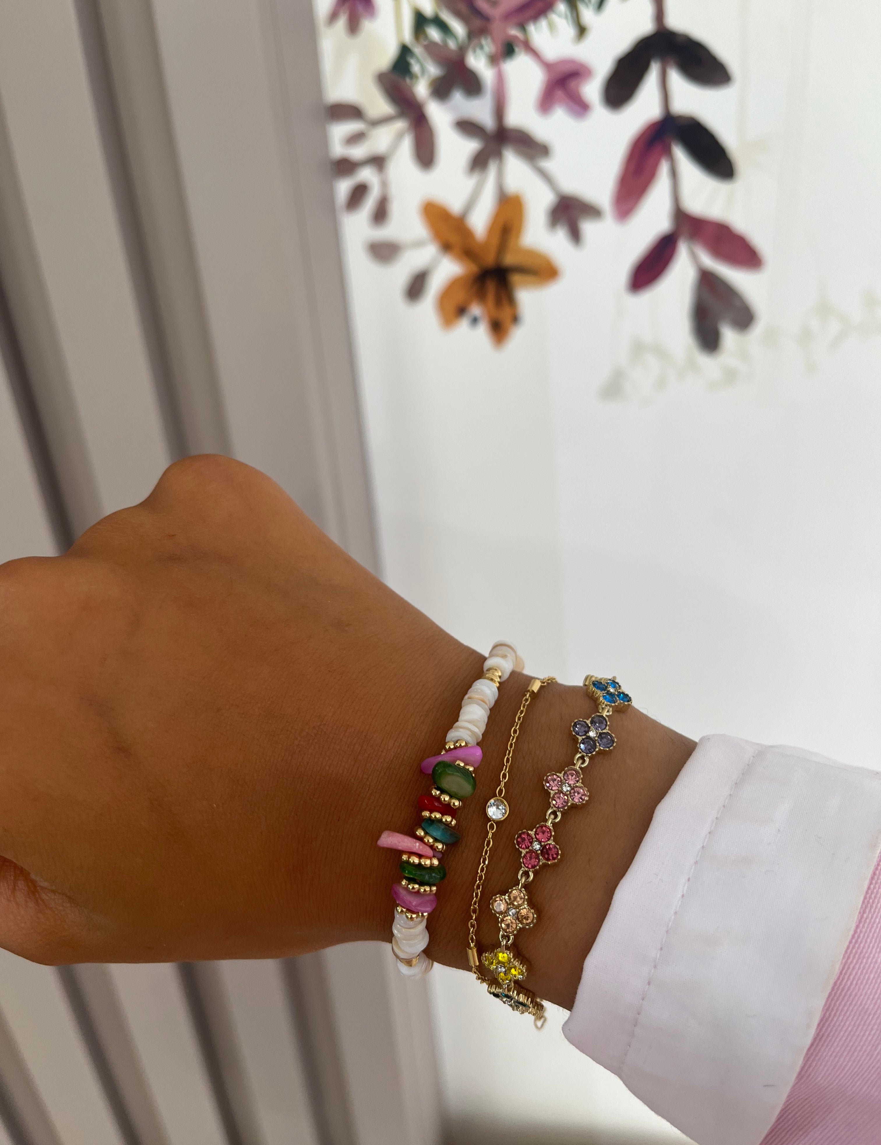 Bracelet Hailey doré en acier inoxydable à fleurs pavées porté en accumulation au poignet - Ordiajade
