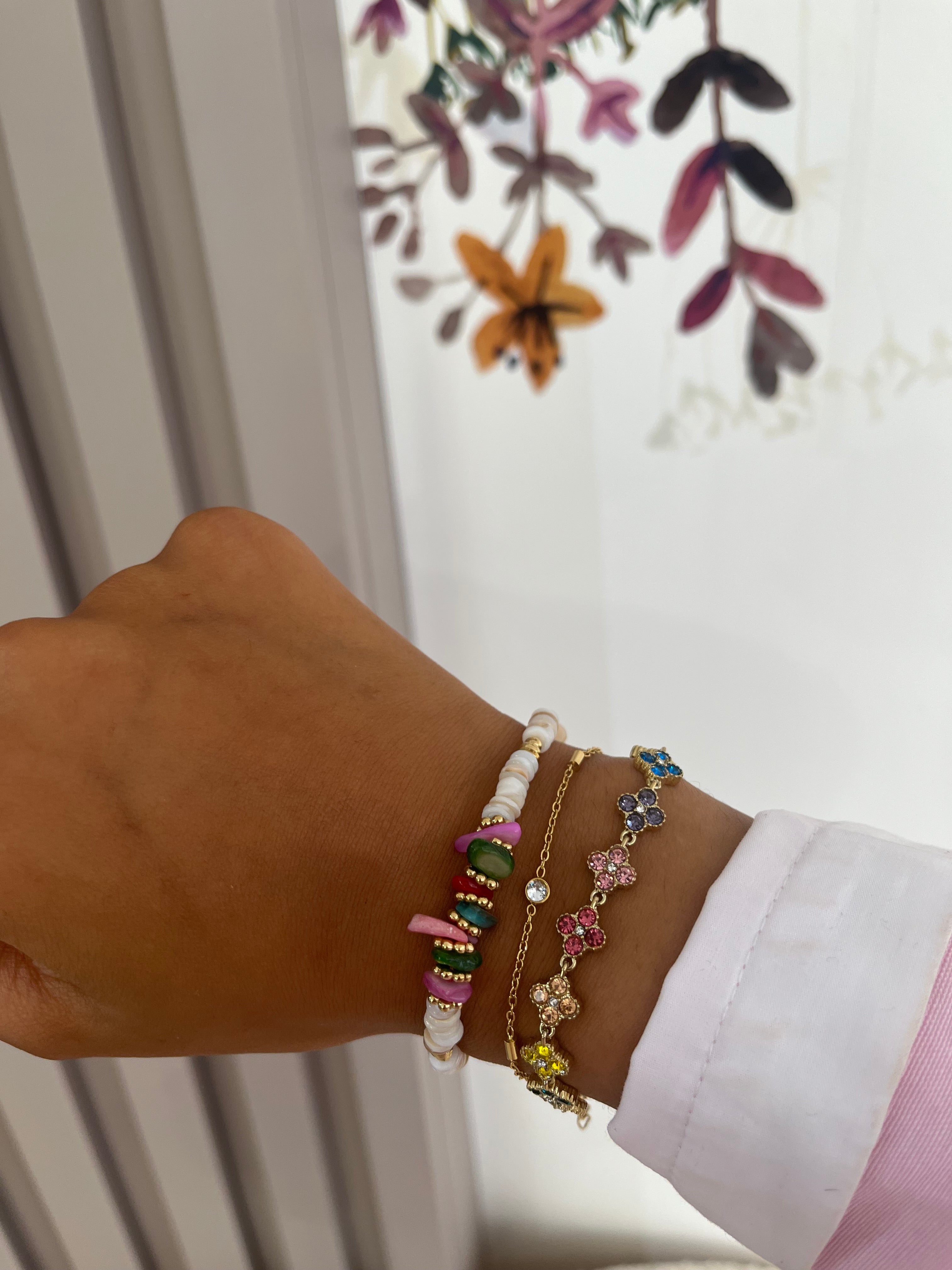Bracelet Hailey doré en acier inoxydable à fleurs pavées porté en accumulation au poignet - Ordiajade