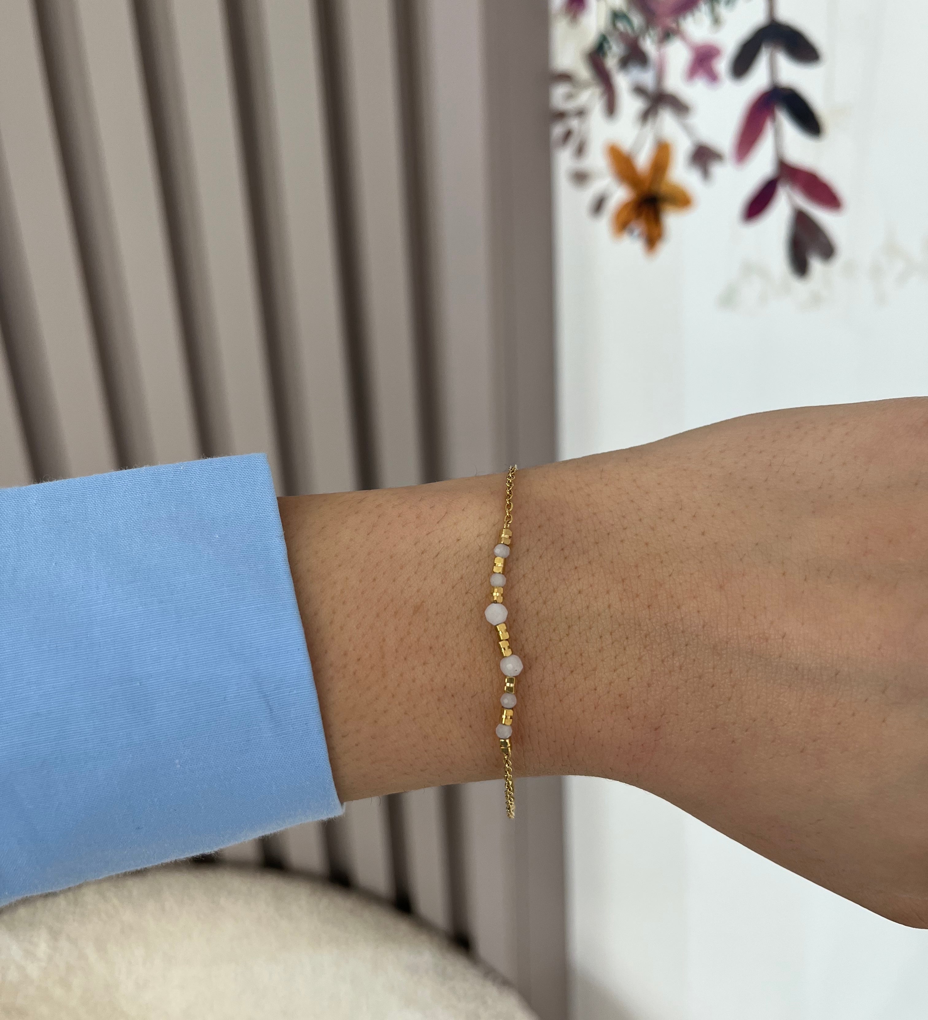 Bracelet Lauria fin en acier inoxydable doré à perles blanches porté au poignet - Ordiajade