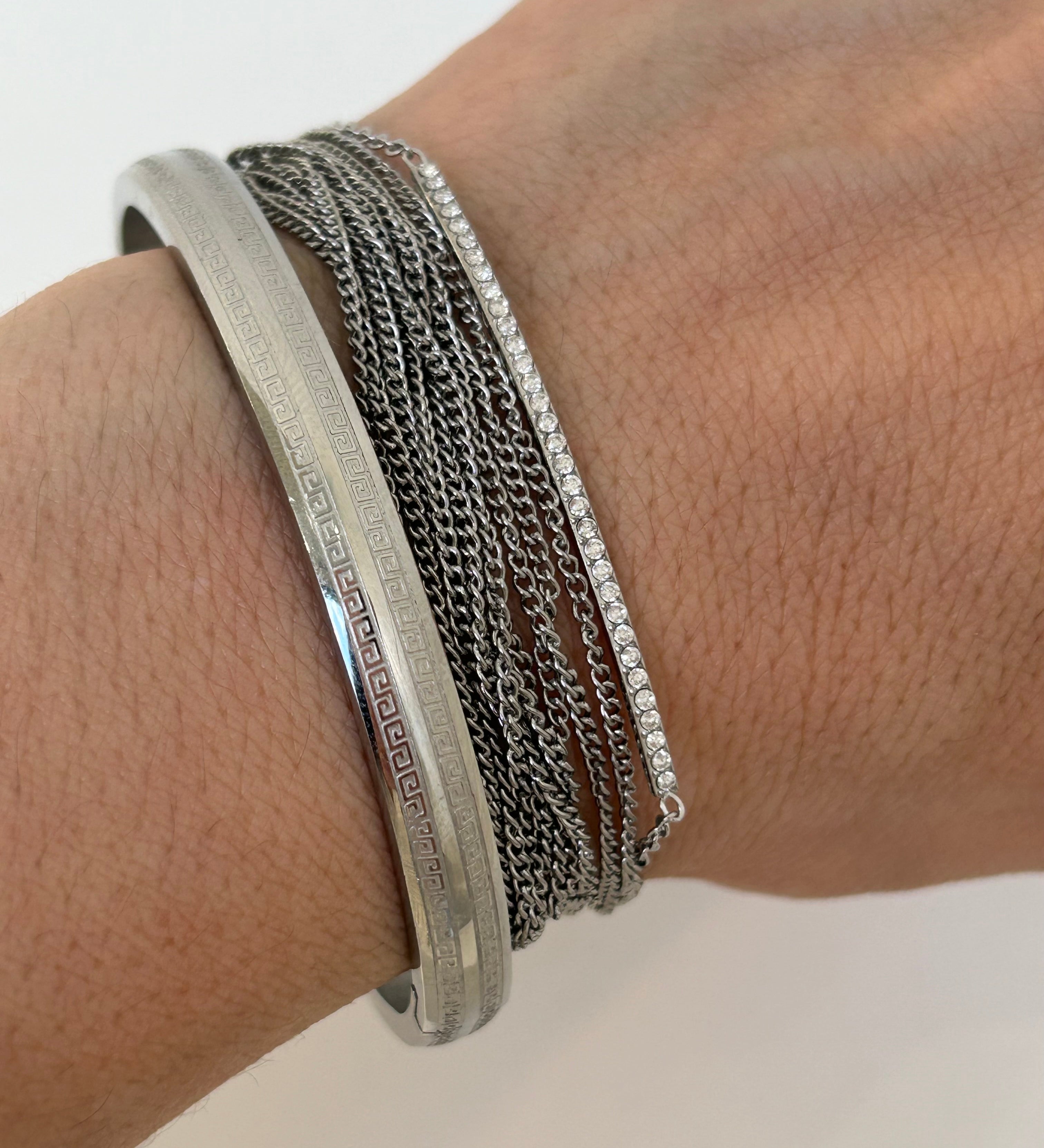 Gros plan sur les fines chaînes argentées du bracelet multirangs Lyv.