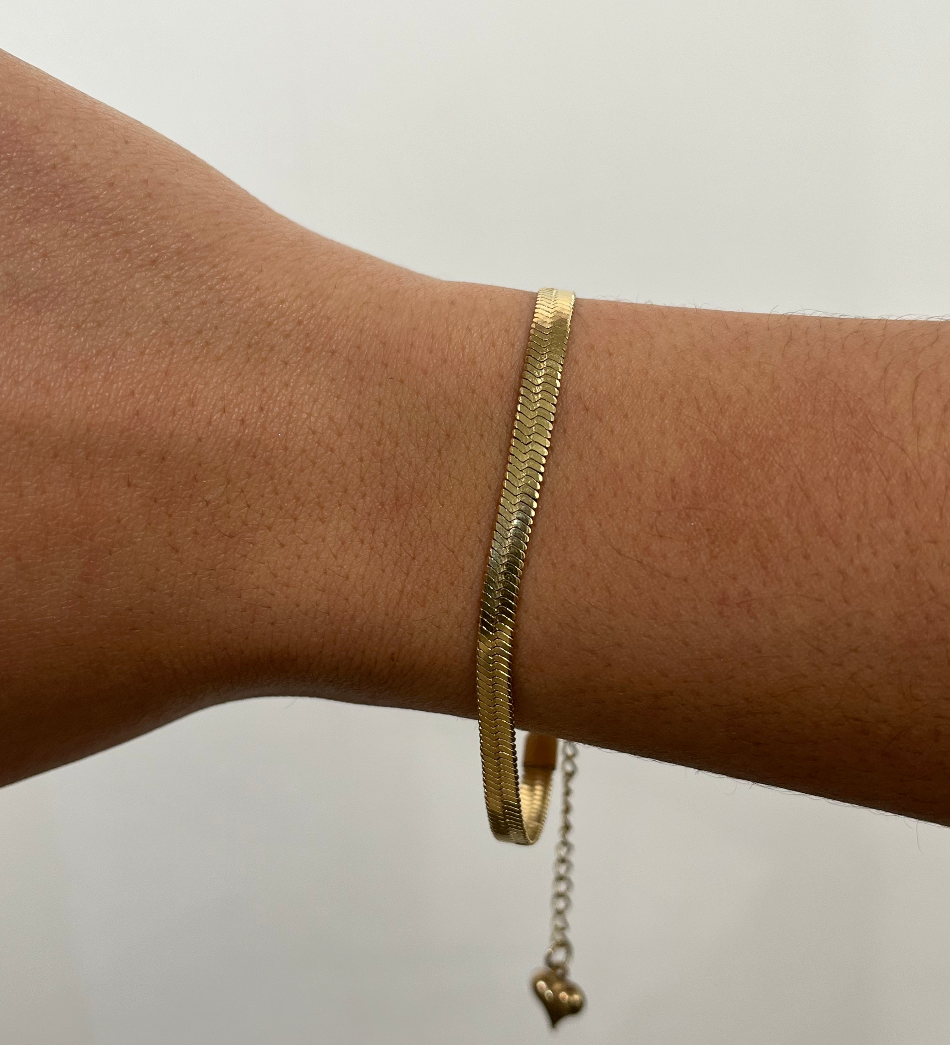 Bracelet doré Serpentia à maille serpent plate porté délicatement au poignet - Ordiajade