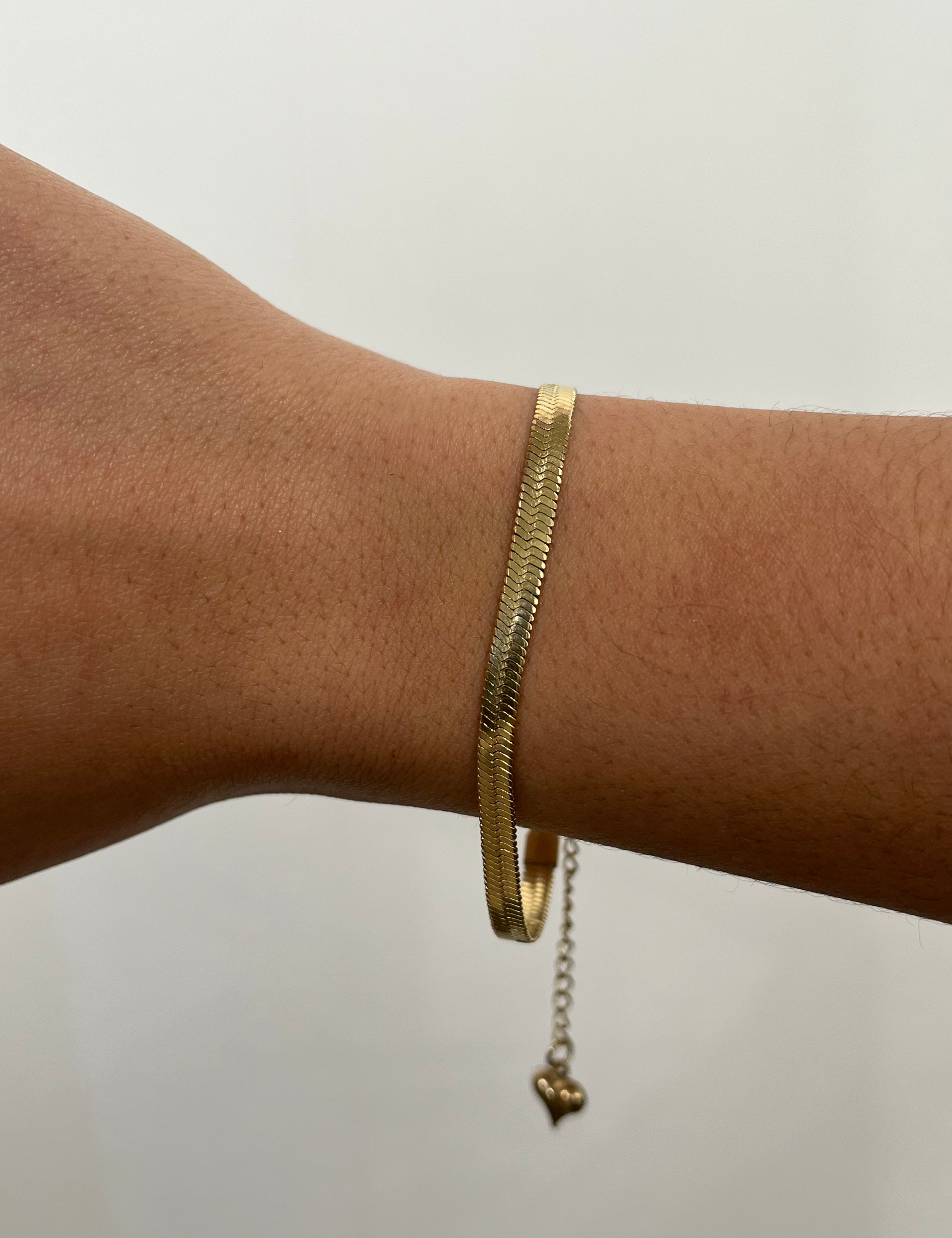 Bracelet doré Serpentia à maille serpent plate porté délicatement au poignet - Ordiajade