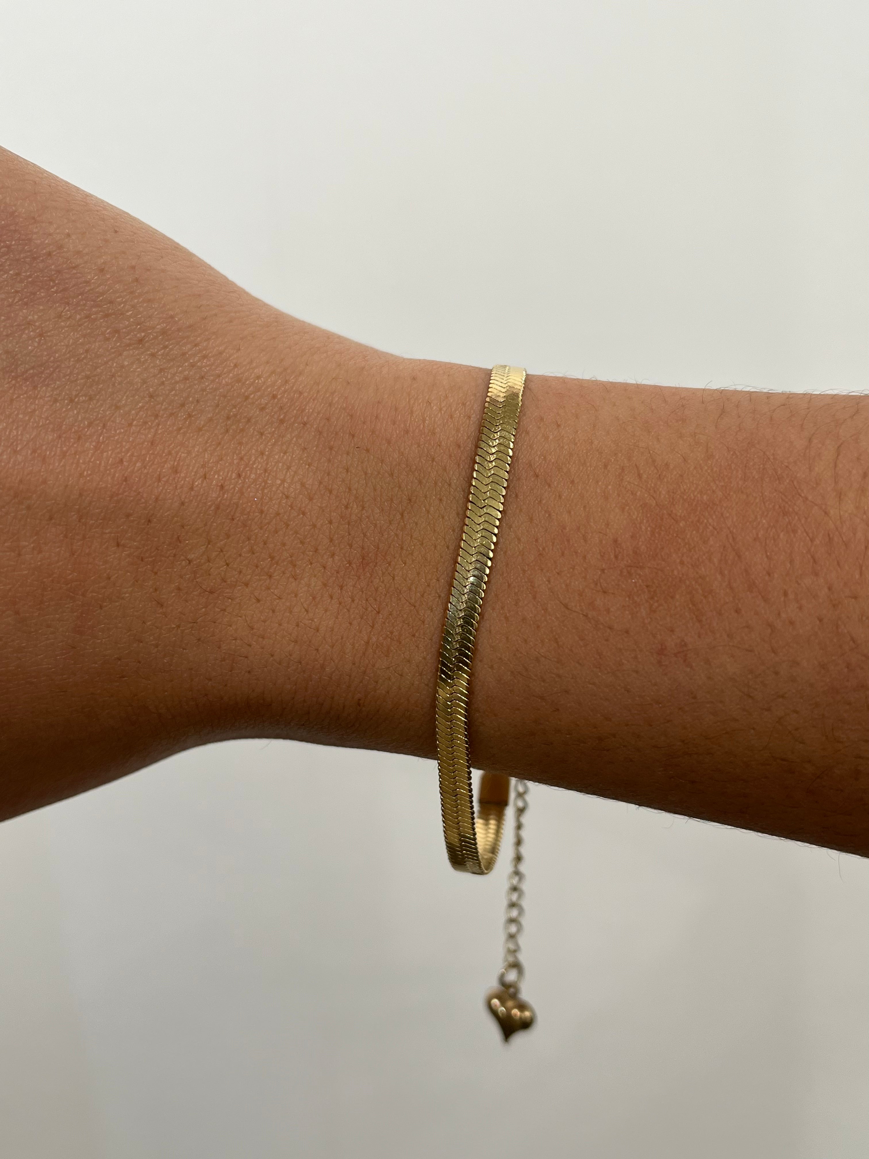 Bracelet doré Serpentia à maille serpent plate porté délicatement au poignet - Ordiajade