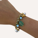 Bracelet Mykonos en acier inoxydable doré avec pierres naturelles vert d'eau porté au poignet - Ordiajade
