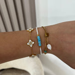 Bracelet Navire doré porté en accumulation avec d'autres bijoux au poignet - Ordiajade