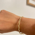 Bracelet Nirvana en chaîne torsadée dorée porté au poignet, bijou minimaliste Ordiajade.