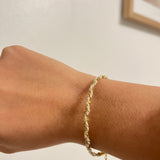 Bracelet Nirvana en chaîne torsadée dorée porté au poignet, bijou minimaliste Ordiajade.