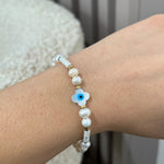Bracelet Someone en perles d'eau douce et acier inoxydable doré avec œil protecteur porté au poignet - Ordiajade