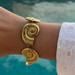 Bracelet Sora doré motif coquillage porté en extérieur au bord de l'eau - Ordiajade
