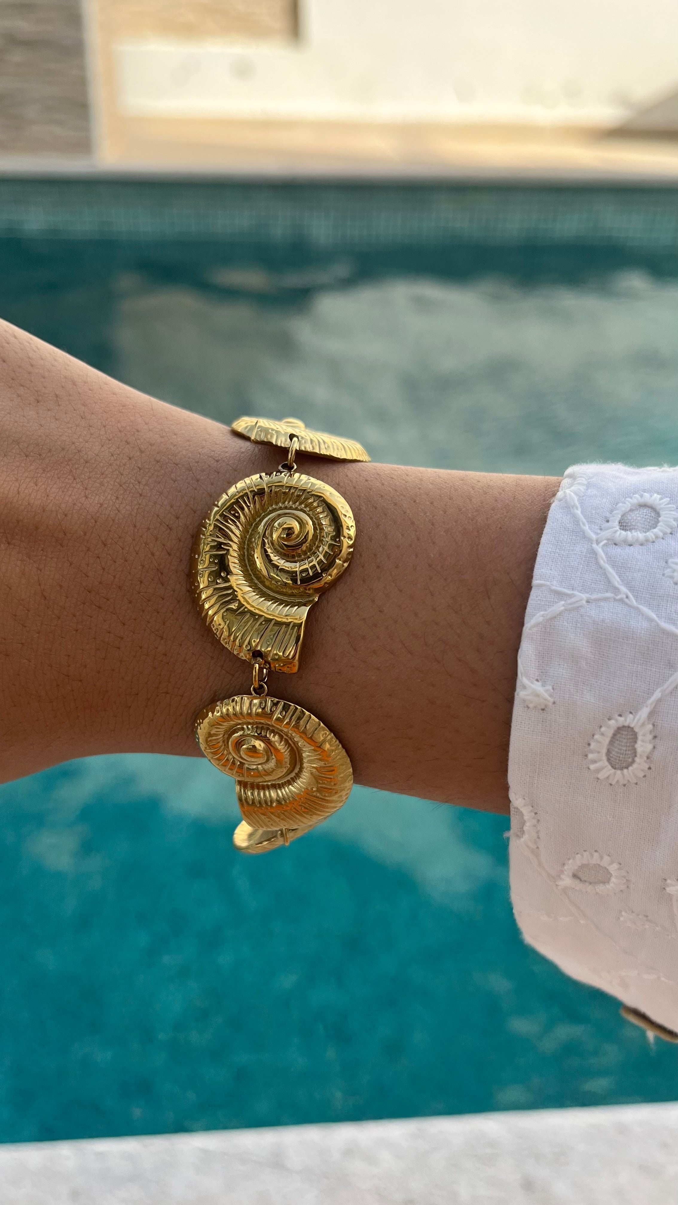 Bracelet Sora doré motif coquillage porté en extérieur au bord de l'eau - Ordiajade
