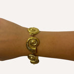 Bracelet Sora motif coquillage en acier inoxydable doré porté au poignet - Ordiajade
