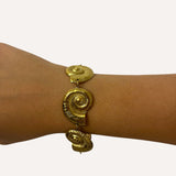 Bracelet Sora motif coquillage en acier inoxydable doré porté au poignet - Ordiajade
