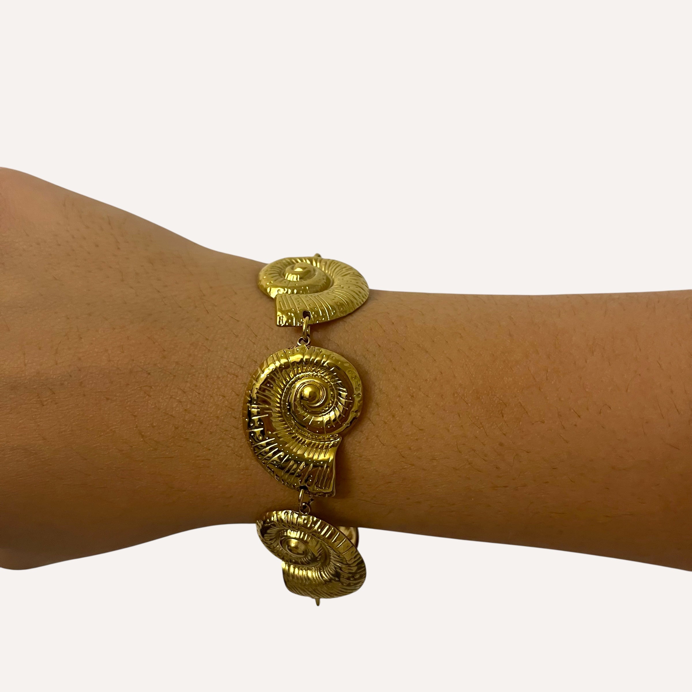 Bracelet Sora motif coquillage en acier inoxydable doré porté au poignet - Ordiajade
