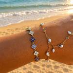 Bracelet Violette en acier inoxydable doré avec trèfles violets porté au poignet à la plage - Ordiajade