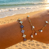Bracelet Violette en acier inoxydable doré avec trèfles violets porté au poignet à la plage - Ordiajade