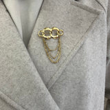 Broche Olympiade dorée en acier inoxydable maillons entrelacés avec chaînettes pendantes portée sur manteau - Ordiajade
