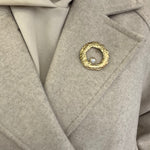 Broche Sylviane dorée en acier inoxydable anneau martelé avec perle portée sur le revers d'un manteau beige - Ordiajade