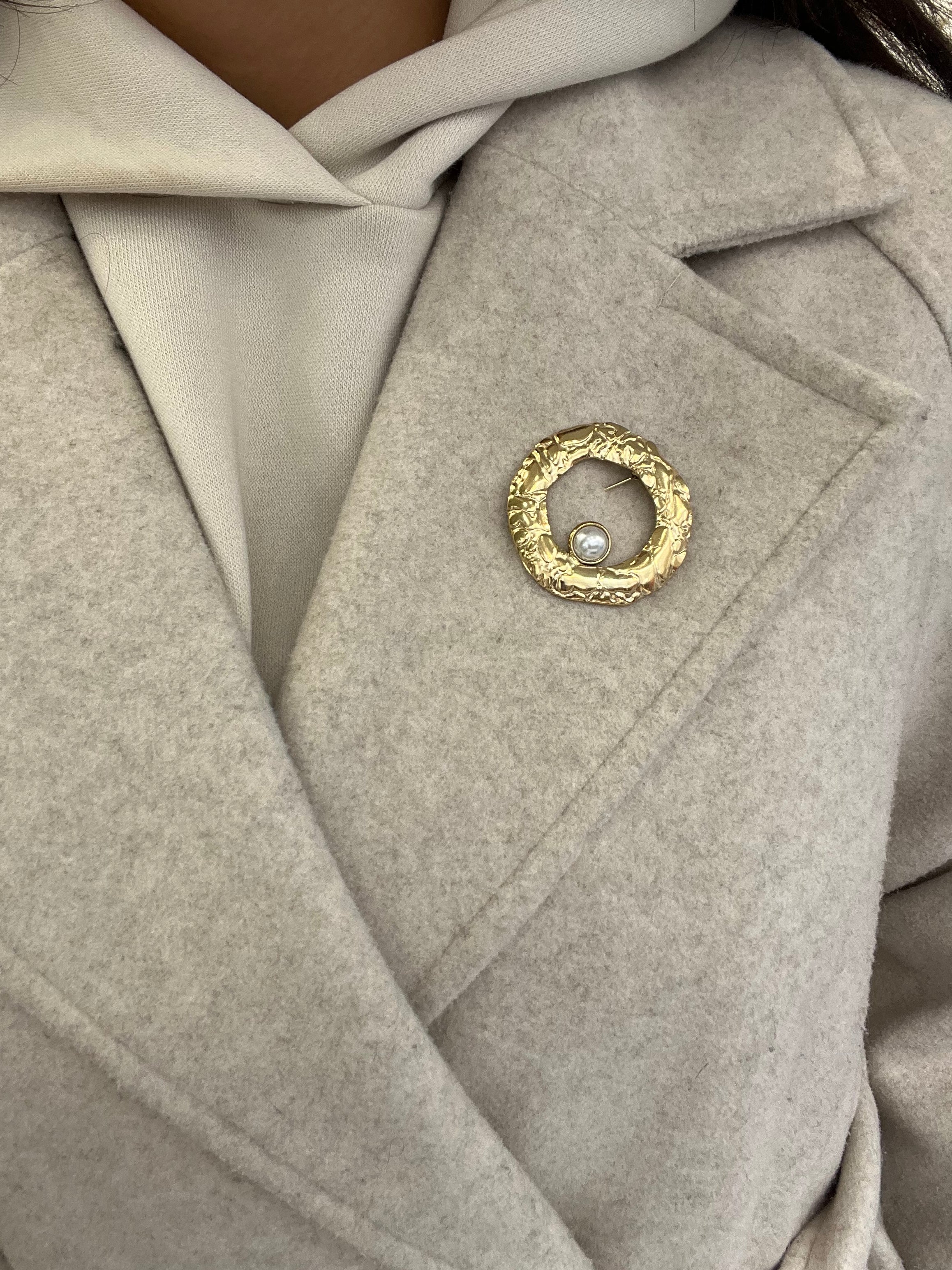 Broche Sylviane dorée en acier inoxydable anneau martelé avec perle portée sur le revers d'un manteau beige - Ordiajade