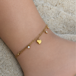 Chaîne de cheville double SHANA en acier inoxydable doré avec cœur et strass portée sur la plage - Ordiajade