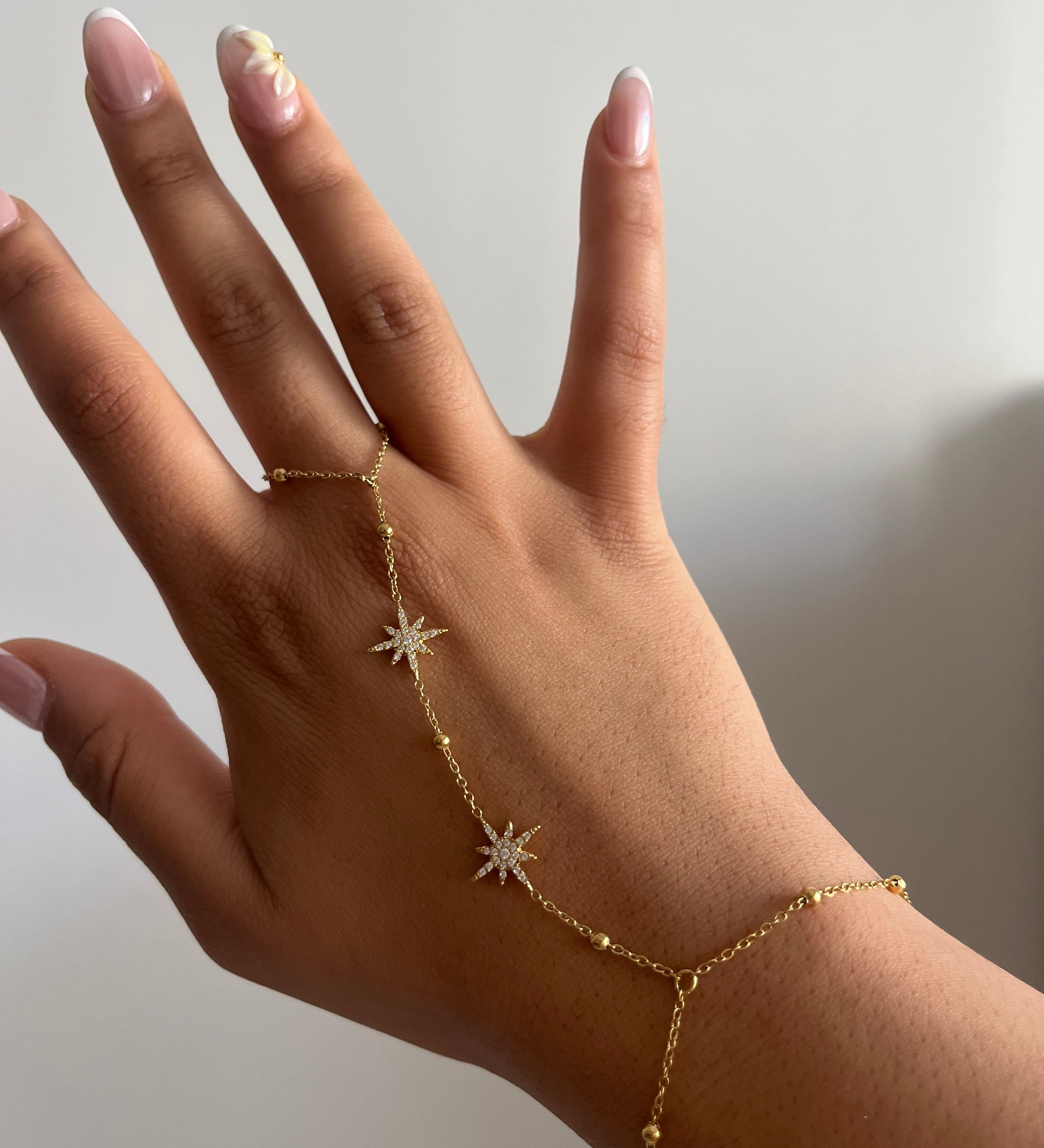 Chaîne de main Météores en acier inoxydable brillant avec des motifs d'étoiles délicats portée sur la main Ordiajade